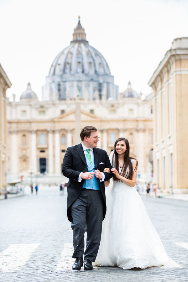 Romantic walk of a beautiful Sposi Novelli couple down Via della Conciliazione with the Vatican in the background