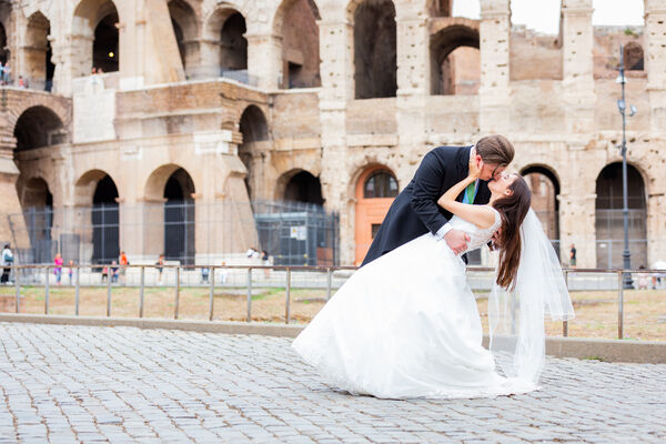 A romantic dip kiss of a Sposi Novelli couple at the Colosseum