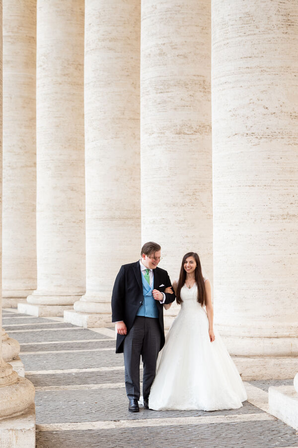 Beautiful Sposi Novelli couple under the colonnade in Saint Peter's Square