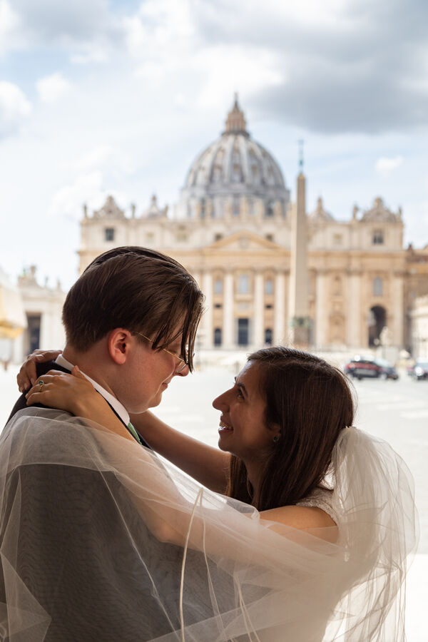 Bride and Groom smiling at each other during their Sposi Novelli photoshoot in Saint Peter's square