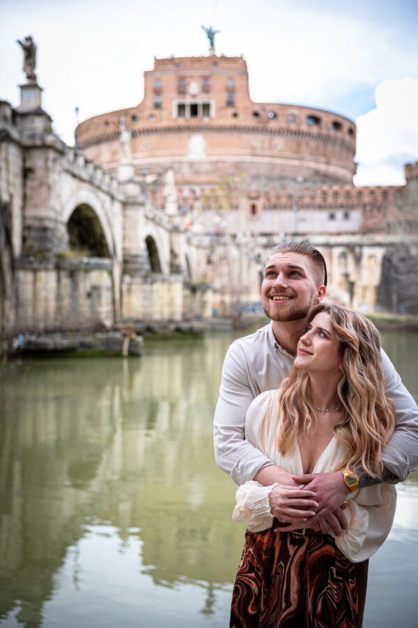 Young couple on vacation in Rome with Castel Sant'Angelo in background